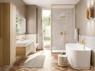 Ein helles Badezimmer mit weißen Waschbecken und hellen Badmöbeln aus Holz. Alle Armaturen sind gold