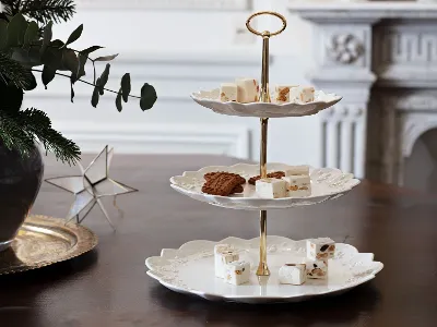 three tier stand of white porcelain plates with dessert on them