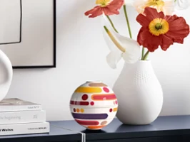 Dekoratives Arrangement mit La Petite Boule Miami und einer weißen Vase auf einem hellen Sideboard