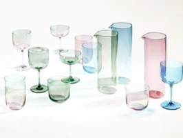 Translucent colored drinking vessels, such as jugs and goblets, are displayed on a white surface.