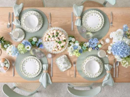 Table dressée pour 4 avec service Villeroy & Boch Easter Delight, fleurs et vases assortis.
