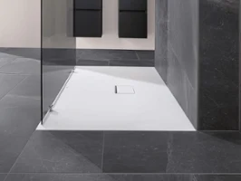 White Squaro Infinity shower tray with a glass shower cubicle and grey tiles. A modern bathroom with a Squaro Infinity shower tray, glass shower cubicle and grey tiles.