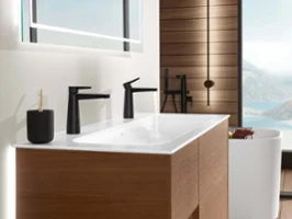 A modern bathroom with a black Conum washbasin tap by Villeroy & Boch and a view of the sea.