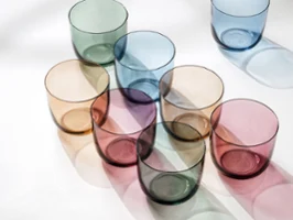 Water glasses in different colours from like. by Villeroy & Boch arranged on a white surface.