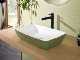 Modern rectangular washbasin on a wooden countertop in a bathroom with a green accent wall