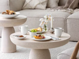 Breakfast with coffee, jam and sandwiches on a beige-coloured coffee table with Villeroy & Boch white Afina crockery.