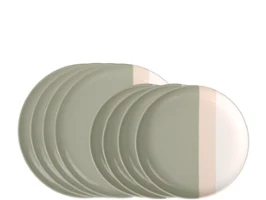 Un juego de platos, cuencos y tazas de cerámica en tonos beige y grises, presentado sobre un fondo claro.