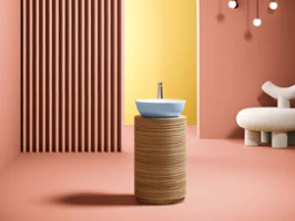 Modernes Badezimmer-Interieur mit rundem, hellblauem Artis Waschbecken, gelbem Bogendetail und stilvoller Beleuchtung