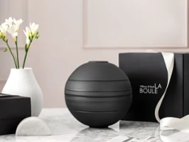 La Boule Black with gift box A black La Boule tableware set on a table with a black gift box behind it.