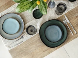 Lave diffrent plates in diffrent colours on a wooden table Top-down view of Villeroy & Boch Lave stoneware plates in different colours, featuring two blue sets on a wooden table.