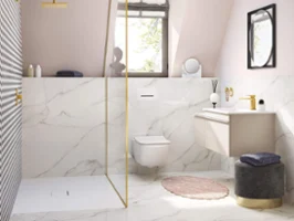 Un lavabo blanc Venticello dans une salle de bains rose mansardée avec des robinetteries dorées