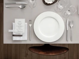 Tischdekoration für eine elegante Feier mit einem Royal Teller, Menükarte, Piemont Besteck und Gläsern von oben betrachtet.