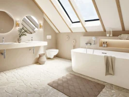 Une baignoire Loop & Friends dans une salle de bains mansardée lumineuse avec du carrelage en pierre naturelle