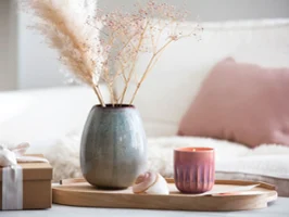 Wooden tray holding a Lave vase and a Perlemor candle with dried flowers, next to a wrapped gift.