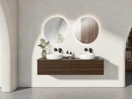 Une salle de bains moderne avec deux miroirs ronds au-dessus de deux lavabos blancs Antao de Villeroy & Boch sur un plan de toilette en bois. Des robinetteries noires et un décor minimaliste complètent le design.