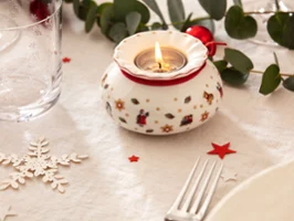 Festive table decoration with a Toy's Delight tea light holder Festive table decoration with a Toy's Delight tea light holder surrounded by green and red accents.