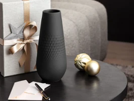 A tall, elegant Manufacture Collier Noir vase with a modern matte black finish and textured surface, Xmas styled as a striking statement piece.