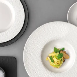 Manufacture ice pasta plate with pasta on it and to the right a bowl with olives in it