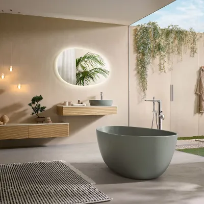 A modern bathroom with a green bath from the Antao collection and coordinating wood-look furniture.