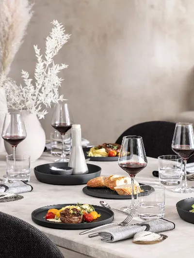 A dining table with a black La Boule being used for food as well as a fully assembled La Boule for decoration.