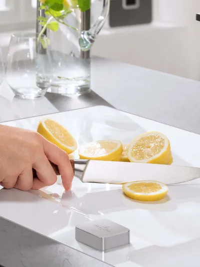 Limón en un fregadero blanco Una persona corta limones sobre un fregadero blanco en una cocina moderna.