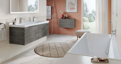 Biała toaleta Subway 3.0 w łazience z jasnopomarańczowymi ścianami Nowoczesna łazienka z pomarańczowymi ścianami i białą wanną Subway 3.0.