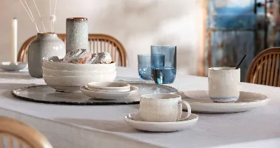 A dining table set with blue glasses from like. Glass and white tableware from the Perlemor collection.