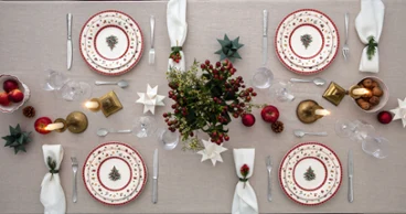 Toys Delight lovingly arranged on a gray table Top-down view of a Christmas-decorated dining table for four people with festive plates, candles, and decorative ornaments.