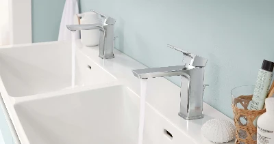 Un lavabo doppio Subway 3.0 con rubinetteria color argento in un bagno con pareti blu.