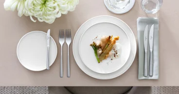 Elegant table decoration with a white Afina gourmet plate, Piemont cutlery and floral decoration.