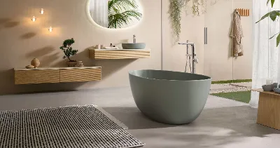 A modern bathroom with a green bath from the Antao collection and coordinating wood-look furniture.