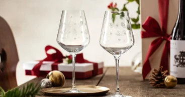 Toy’s Delight jars with gift packaging in the background A pair of Toy’s Delight wine glasses from Villeroy & Boch on a table surrounded by wrapped gifts, a bottle of wine, and festive decorations.