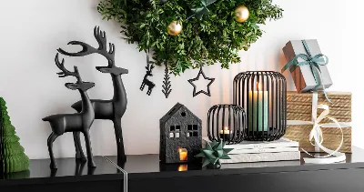 Modern Black XMAS Christmas decoration with a green wreath on a mantelpiece.