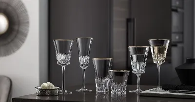 Elegant Grand Royal glasses on a counter in a modern kitchen with dark cupboards in the background.