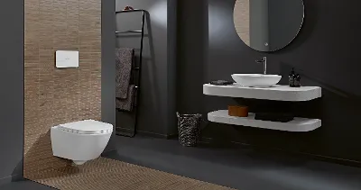 A bathroom with a Universo TwistFlush toilet by Villeroy & Boch, a washbasin and a mirror.