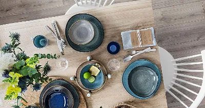 A wooden table with Villeroy & Boch Lave plates on top.