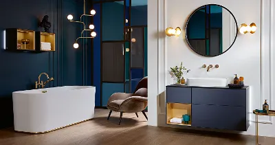 A bathroom with blue walls, with harmonious Finion bathroom furniture and a white Finion bath by Villeroy & Boch.