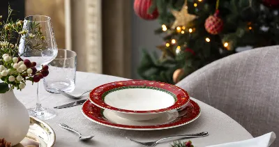 Elegant Toys Delight holiday plates with decorative accessories and a Manufacture Blanc vase styled for a festive table setting.