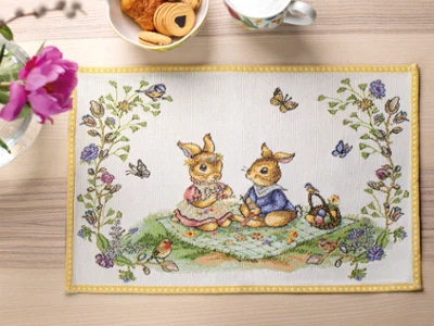 Spring Fantasy placemat with butterflies, flowers, and birds on a wooden table with snacks and a flower vase.