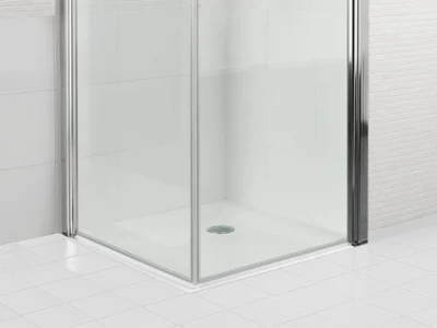 Czysty, pusty, przeszklony prysznic O.novo z wyłożoną kafelkami podłogą i ścianami oraz odpływem pośrodku.