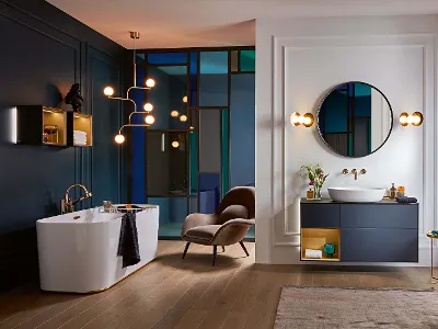 Finion bath in a classic bathroom with blue walls and wooden floors.