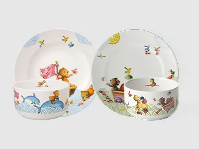 Zwei Sets Kindergeschirr mit Tierillustrationen, darunter Bären, Vögel und Schmetterlinge auf weißem Hintergrund.