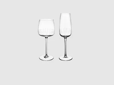 Ein Weinglas und ein Champagnerglas stehen nebeneinander auf einem schlichten hellgrauen Hintergrund.