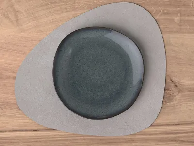 A Lave plate on a grey Lifestyle Accessories placemat on a wooden table.