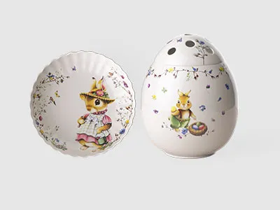 Ein dekorativer Teller und eine eiförmige Vase, beide mit aufgemalten Tierfiguren und Blumenmustern.