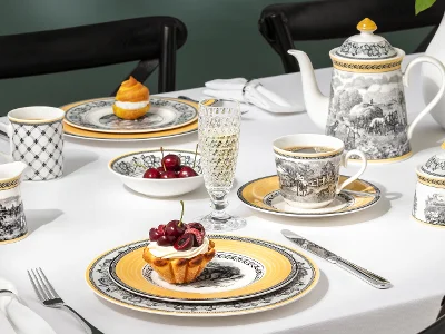 Élégante table à manger présentant la collection Audun, accompagnée de verres Boston et d'un assortiment de desserts.
