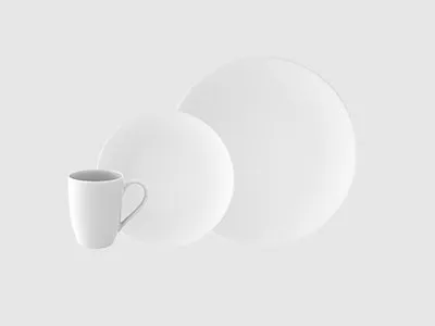 Auf einem schlichten hellen Hintergrund sind eine weiße Keramiktasse, ein kleiner Teller und ein großer Teller angeordnet.