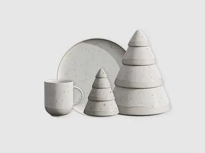 Ein Set aus weißem Keramikgeschirr, darunter eine Tasse, ein Teller und stapelbare, baumförmige Schalen, auf einem schlichten Hintergrund.