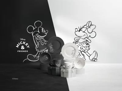 Se amplía la gama de platos y tazas blancos y negros de la colección Manufacture Mickey. Una serie de platos y tazas blancos y negros de la colección Manufacture Mickey, dispuestos sobre una superficie dividida en dos mitades, una blanca y otra negra.