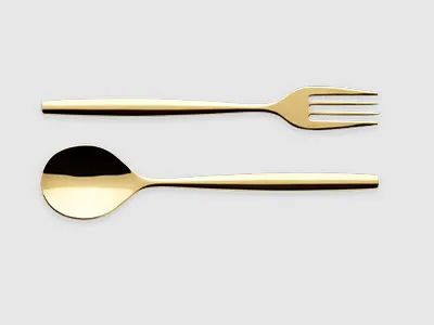Eine goldfarbene Gabel und ein Löffel liegen nebeneinander auf einem schlichten hellgrauen Hintergrund.